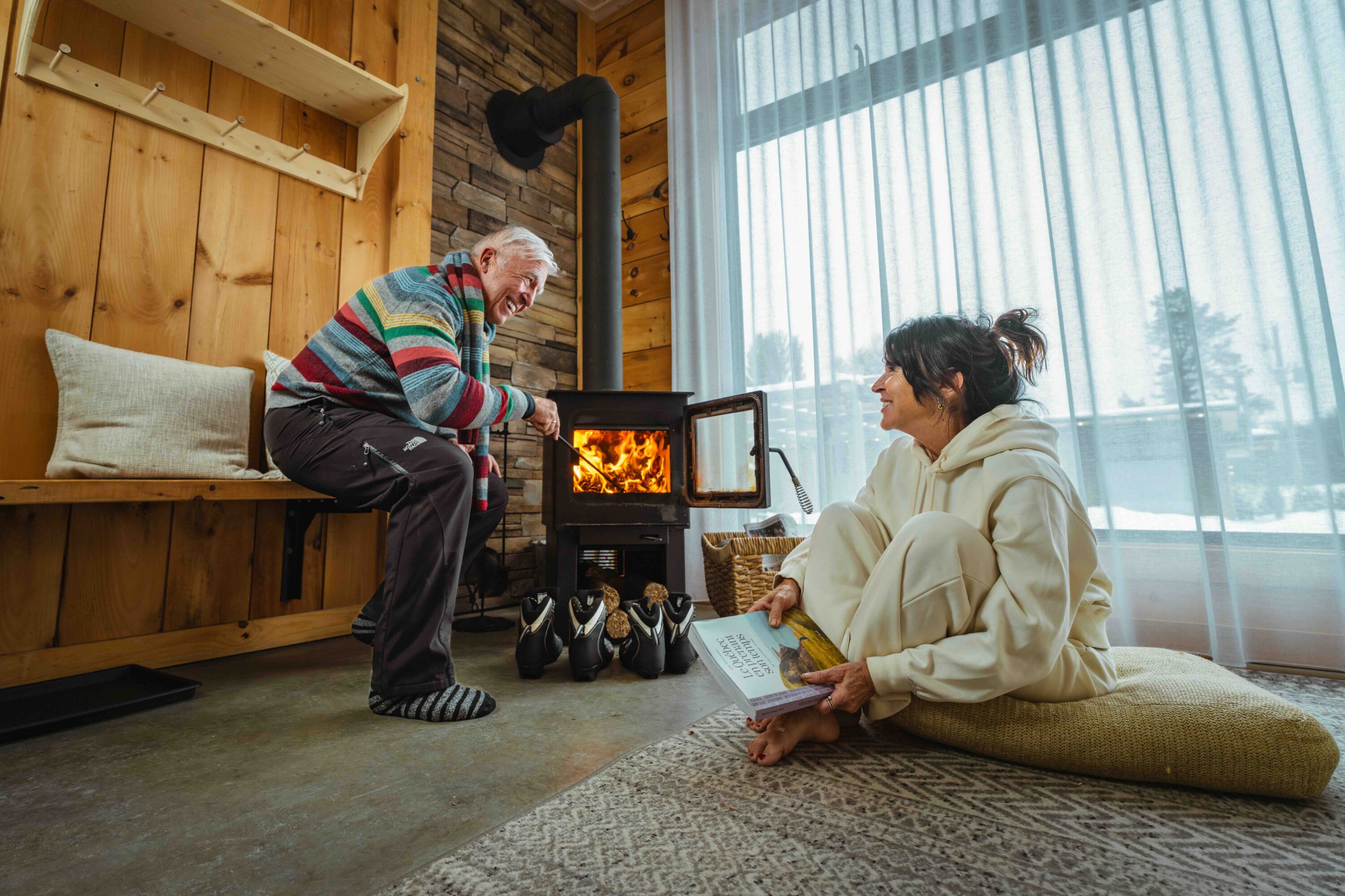 Un couple profite d’un moment de détente près du poêle à bois dans un chalet chez Le 2800 du Parc